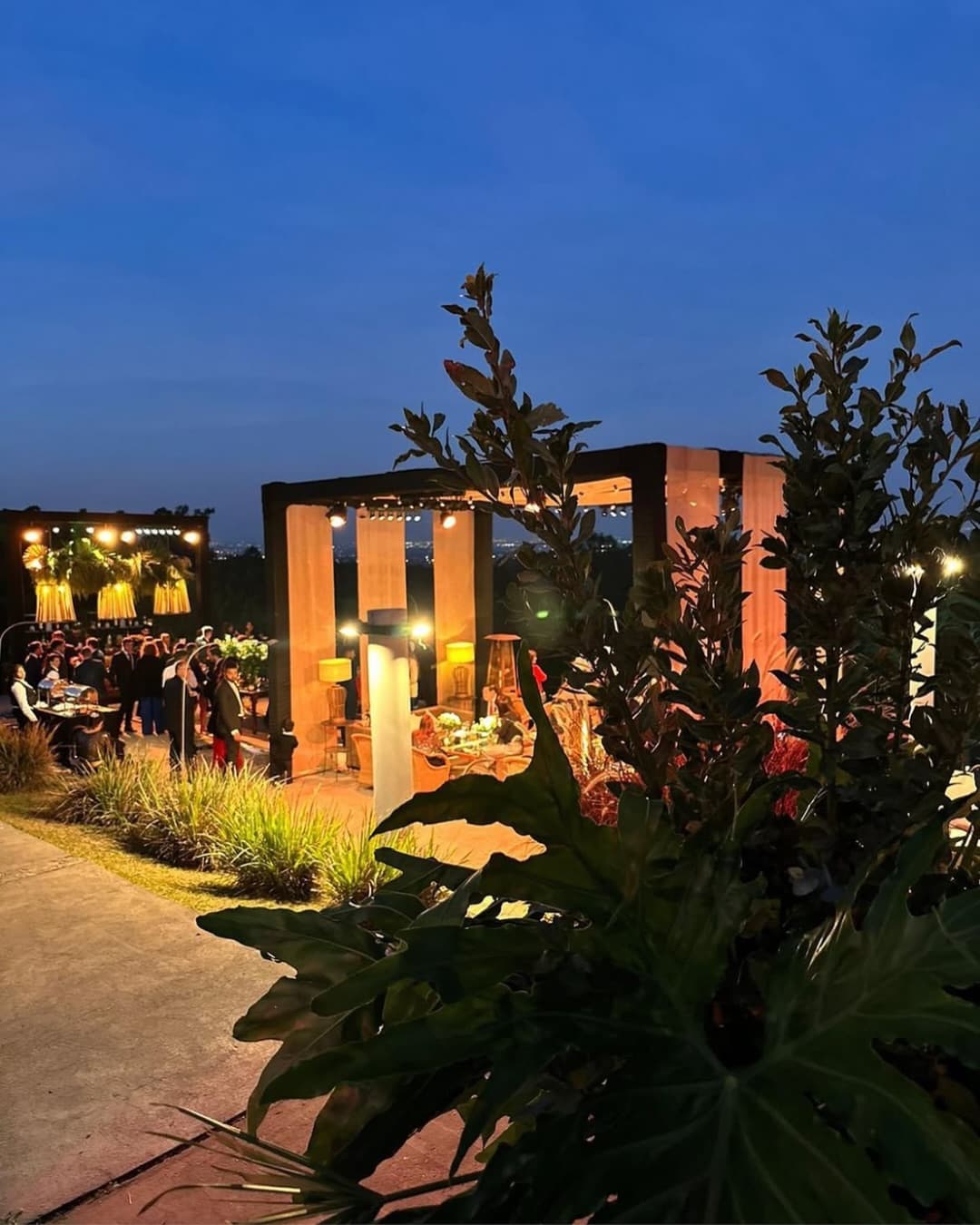 El parque del salón a la hora azul, con la pérgola iluminada.